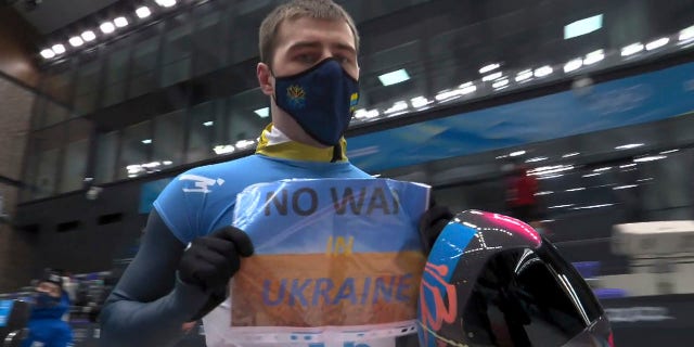 FILE - In this frame from video, Vladyslav Heraskevych, of Ukraine, holds a sign that reads