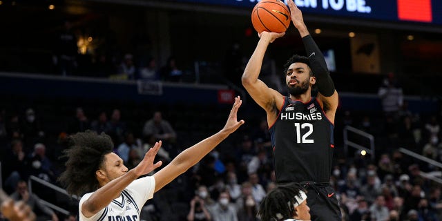 Connecticut forward Tyler Polley (12) shoots against Georgetown forward Jalin Billingsley (4) and guard Dante Harris (2) during the first half of an NCAA college basketball game, Sunday, Feb. 27, 2022, in Washington.