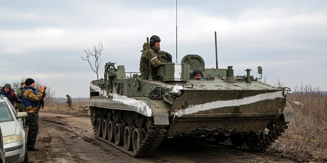 A cameraman films as an armored vehicle rolls outside Mykolaivka, Donetsk region, the territory controlled by pro-Russian militants, eastern Ukraine, Sunday, Feb. 27, 2022. Fighting also raged in two eastern territories controlled by pro-Russia separatists. (WHD Photo)