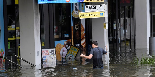 A man wades through floodwaters in suburban Brisbane, オーストラリア, 月曜, 2月. 28, 2022.