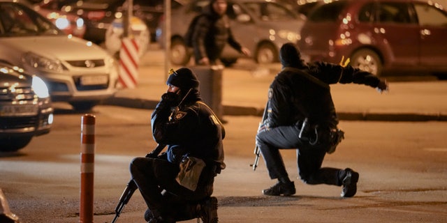 Ukrainian police rush a traveler to the railway station terminal during an airstrike alarm in Kyiv, Ukraine, Monday, Feb. 28, 2022. 