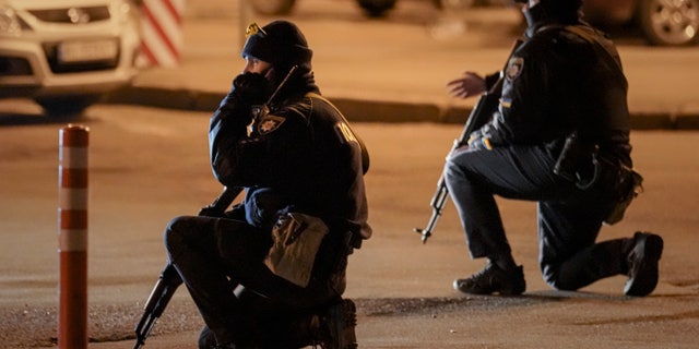 Ukrainian police gesture during an airstrike alarm outside the railway station in Kyiv, Ukraine, Monday, Feb. 28, 2022. Explosions and gunfire that have disrupted life since the invasion began last week appeared to subside around Kyiv overnight, as Ukrainian and Russian delegations met Monday on Belarus border.