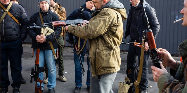 Civilian Members of a territorial defence unit fit their weapons to repel the Russian attacking forces in Kyiv, Ukraine, Saturday, Feb. 26, 2022. Russian troops stormed toward Ukraine's capital Saturday, and street fighting broke out as city officials urged residents to take shelter.