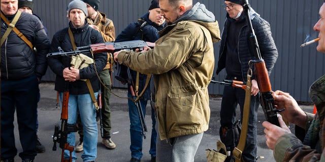 Civilian Members of a territorial defence unit fit their weapons to repel the Russian attacking forces in Kyiv, Ukraine, Saturday, Feb. 26, 2022. Russian troops stormed toward Ukraine's capital Saturday, and street fighting broke out as city officials urged residents to take shelter.