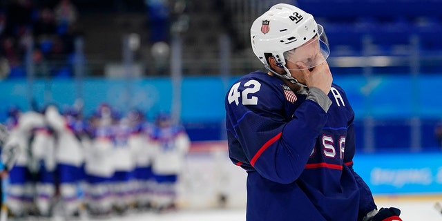 Le joueur américain Aaron Ness (42 ans) quitte la glace alors que les joueurs slovaques célèbrent derrière lui après leur match de hockey masculin en quart de finale aux Jeux olympiques d'hiver de 2022 le 16 février 2022 à Pékin.  La Slovaquie a gagné 3-2 aux tirs au but.