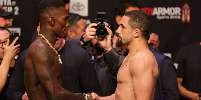 Israel Adesanya of Nigeria faces Robert Whittaker of Australia at the ceremonial weigh-in prior to UFC 271 at Toyota Center Feb. 11, 2022, in Houston.