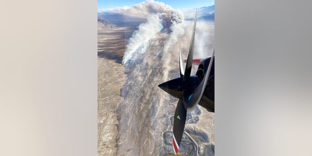 This photo provided by CAL FIRE San Bernardino Unit Public Information Office shows smoke from a blaze that erupted Wednesday, Feb. 16, 2022, near Eastern Sierra Regional Airport just outside the town of Bishop, Calif.