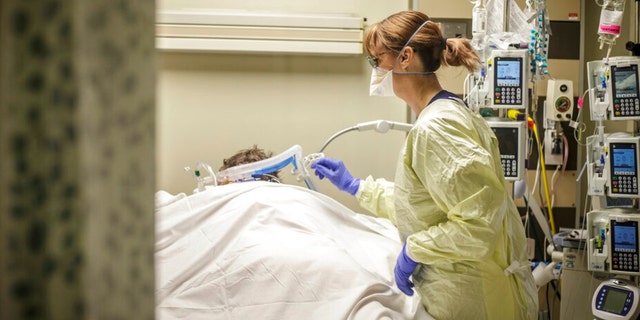 Jessica Moore, RN, adds a blanket over a COVID-19 positive patient in prone position due to being on a ventilator inside the infectious disease unit (IDU} Friday at Helen Keller Hospital. [DAN BUSEY/TIMESDAILY]
