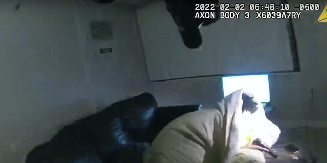 A Minneapolis police body camera image shows 22-year-old Amir Locke wrapped in a blanket on a couch, holding a gun, moments before he was fatally shot by police as they were executing a search warrant in a homicide investigation.