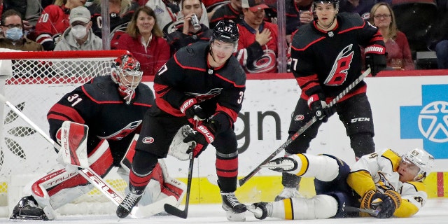 Carolina Hurricanes right wing Andrei Svechnikov (37) controls the puck in front of goaltender Frederik Andersen (31) and defenseman Tony DeAngelo, top right, next to fallen Nashville Predators center Mikael Granlund during the second period of an NHL hockey game Friday, 2 월. 18, 2022, in Raleigh, 체크 안함.
