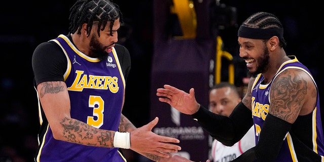 Lakers forward Anthony Davis, left, celebrates with forward Carmelo Anthony after scoring against the Portland Trail Blazers, Feb. 2, 2022, in Los Angeles.