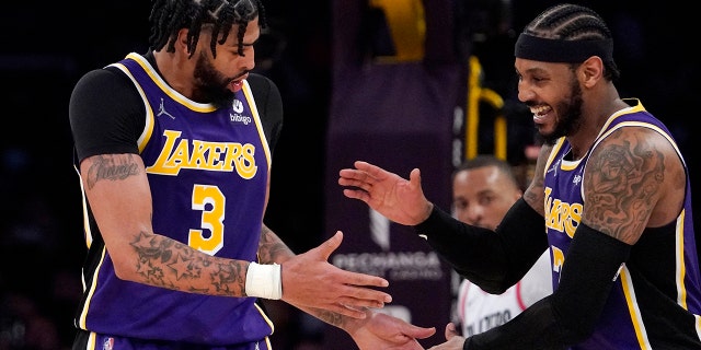 Lakers forward Anthony Davis, left, celebrates with forward Carmelo Anthony after scoring against the Portland Trail Blazers, Feb. 2, 2022, in Los Angeles.