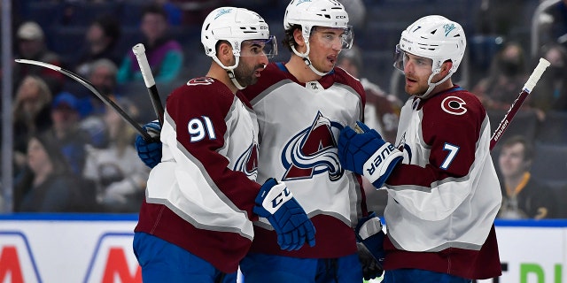 Colorado Avalanche center Nazem Kadri, left, celebrates with left wing Andre Burakovsky, center and defenseman Devon Toews after scoring against the Buffalo Sabres during the first period of an NHL hockey game in Buffalo, N.Y., Saturday, Feb. 19, 2022.