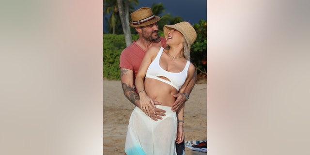 Brian Austin Green and Sharna Burgess confirmed they are expecting their first child together with a beachside photo shoot in Maui.