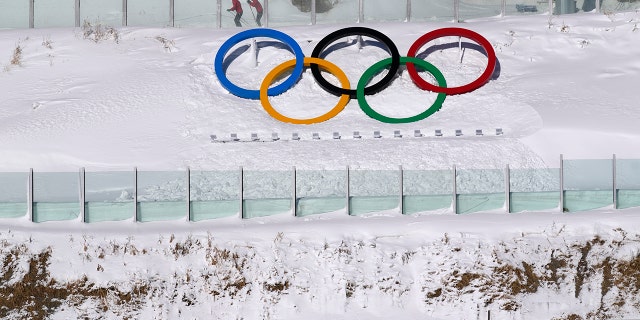 Biathletes skate above the Olympic rings during practice at the 2022 Winter Olympics, Thursday, Feb. 3, 2022, in Zhangjiakou, China.