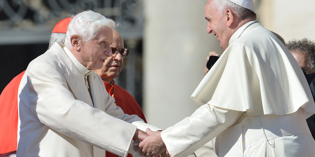 Pope emeritus Benedict XVI speaks with Pope Francis during a papal mass for elderly people at St Peter's square on Sept. 28, 2014 at the Vatican.