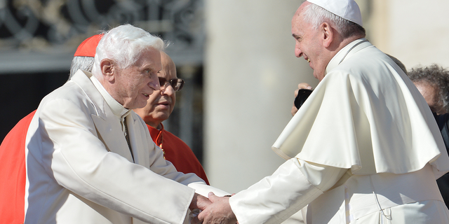 Pope emeritus Benedict XVI, left, speaks with Pope Francis during a papal Mass for elderly people at St. Peter's Square on Sept. 28, 2014, at the Vatican.