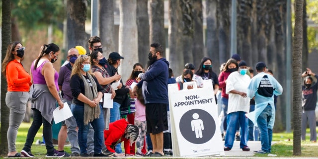 People wait in line to test for COVID-19 on Wednesday, Jan. 12, 2022, in Long Beach, Calif.