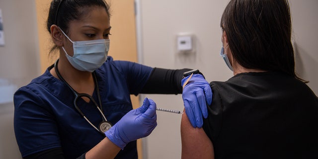 A health care worker administers a third dose of the Moderna COVID-19 vaccine at the CareNow Denver University urgent care center in Denver, Colorado, on Tuesday, Nov. 16, 2021. 