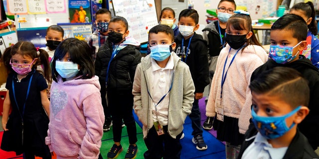 Kindergarteners wear masks while listening to their teacher amid the COVID-19 pandemic at Washington Elementary School on Jan. 12, 2022, in Lynwood, California.
