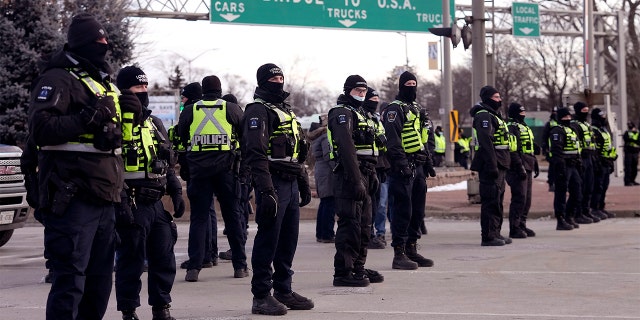 Police line up in preparation to enforce an injunction against a demonstration against COVID-19 restrictions that blocked traffic across the Ambassador Bridge, in Windsor, Ontario, Feb. 12, 2022.