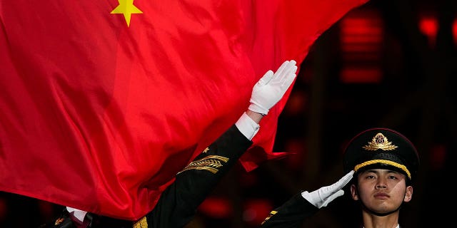 A Chinese flag is raised during a medal ceremony for the women's freestyle skiing big air at the 2022 Winter Olympics