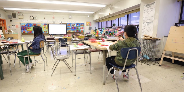 Masked students receive an in-person art lesson at Yung Wing School P.S. 124 on January 05, 2022, in New York City. (Photo by Michael Loccisano/Getty Images)