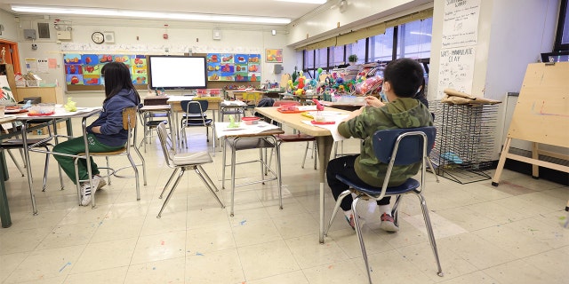 Masked students receive an in-person art lesson at Yung Wing School P.S. 124 on January 05, 2022, in New York City. (Photo by Michael Loccisano/Getty Images)