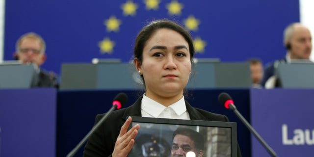 Jewher Ilham, daughter of Ilham Tohti, Uyghur economist and human rights activist, holds a portrait her father during the award ceremony for his 2019 European Parliament's Sakharov human rights prize at the European Parliament in Strasbourg, eastern France, on December 18, 2019. 