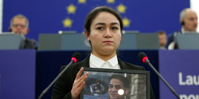 Jewher Ilham, daughter of Ilham Tohti, Uyghur economist and human rights activist, holds a portrait her father during the award ceremony for his 2019 European Parliament's Sakharov human rights prize at the European Parliament in Strasbourg, eastern France, on December 18, 2019.