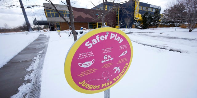 A sign advises visitors of rules in place to combat the spread of coronavirus along a walkway leading to the Children's Museum of Denver at Marsico Campus on Thursday, Jan. 27, in Denver. The popular museum temporarily closed last week because of escalating harassment of staff by adult visitors angry over a city-ordered mandate requiring anyone age 2 and older to wear a mask in indoor public spaces. The museum will remain closed until Friday, Feb. 4.