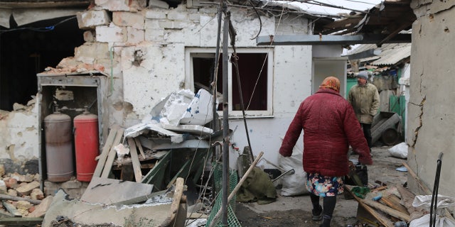 A woman is seen in front of a damaged building in Donetsk's Petrovskaya, which is under control of pro-Russian separatists, as Russian attacks continue in Ukraine on February 28, 2022.