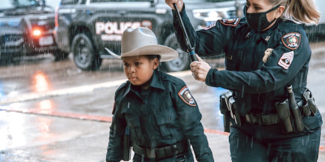 Devarjaye "DJ" Daniel, 10, is sworn into his 100th law enforcement agency. (Houston Independent School District)