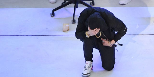 Eminem is seen kneeling behind Dr. Dre during the 2022 Super Bowl Halftime Show.