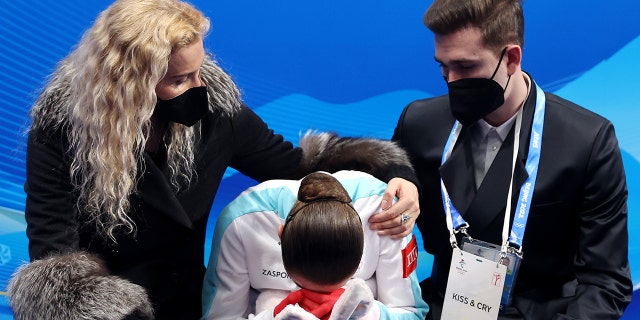 Kamila Valieva of Team ROC reacts to their score with choreographer Daniil Gleikhengauz (R) and coach Eteri Tutberidze (L) after the Women Single Skating Free Skating on day thirteen of the Beijing 2022 Winter Olympic Games at Capital Indoor Stadium on Feb. 17, 2022 in Beijing, China.