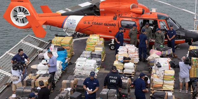 U.S. Coast Guard personnel and members of the media.