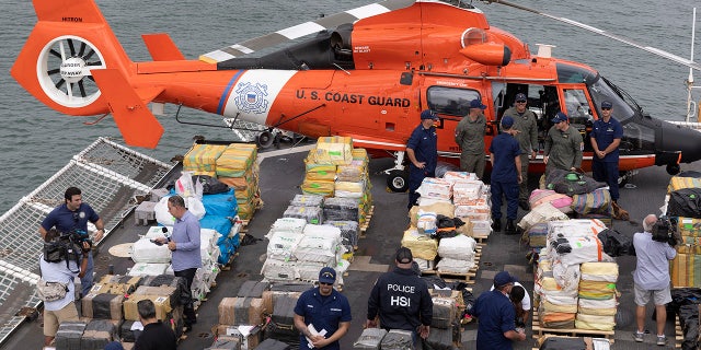 U.S. Coast Guard personnel and members of the media.