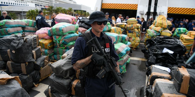 US Coast Guard personnel stand on the deck of Cutter James as they offload approximately $1.06 Billion in cocaine, marijuana at the Port Everglades in Fort Lauderdale, Florida on February 17, 2022.