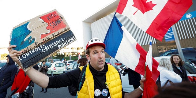 A French activist holds a poster reading "Resistance" before the start of their "Convoi de la liberte" (The Freedom Convoy), a vehicular convoy protest converging on Paris to protest coronavirus disease (COVID-19) vaccine and restrictions in Nice, France, February 9, 2022.