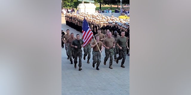 Francis Thomas, 20, son of 9/11 responder Frank Thomas, carried the American flag to Bancroft Hall at the U.S. Naval Academy in Annapolis, Maryland, during a 9/11 memorial relay event on Sept. 11, 2021.