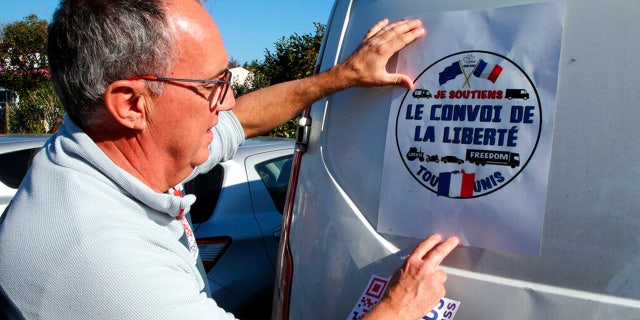 A man puts a poster reads