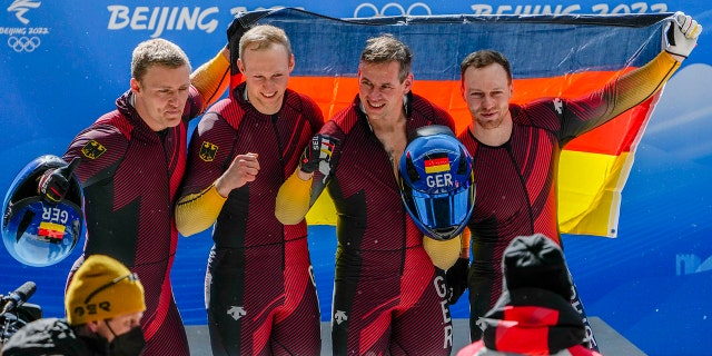 Francesco Friedrich, Thorsten Margis, Candy Bauer and Alexander Schueller, of Germany, celebrate winning the gold medal in the 4-man at the 2022 冬奥会, 星期日, 二月. 20, 2022, in the Yanqing district of Beijing.