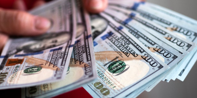 One hundred US dollar banknotes are seen on display. (Photo Illustration by Igor Golovniov/SOPA Images/LightRocket via Getty Images)