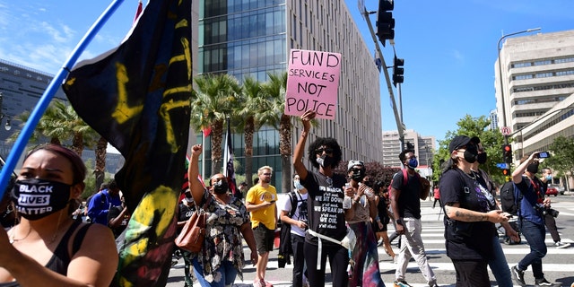 Activists and supporters of Black Lives Matter, march on the one-year anniversary of George Floyd's death on May 25, 2021 in Los Angeles, California. (Photo by FREDERIC J. BROWN/AFP via Getty Images)