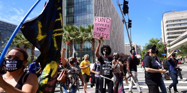 Activists and supporters of Black Lives Matter, march on the one-year anniversary of George Floyd's death on May 25, 2021 in Los Angeles, California. (Photo by FREDERIC J. BROWN/AFP via Getty Images)