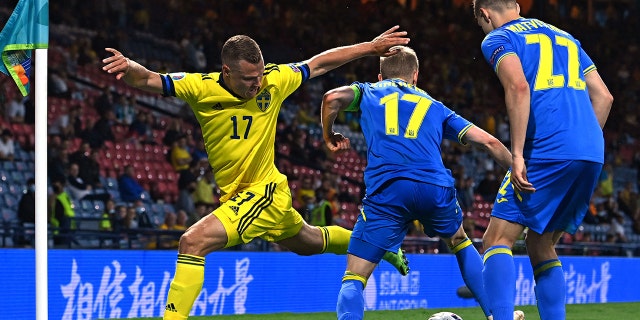 Sweden's midfielder Viktor Claesson (left) gets involved with Ukraine's defender Oleksandr Zinchenko (center) and Mykola Matviyenko during the UEFA EURO 2020 quarterfinals between Sweden and Ukraine at Hampden Park in Glasgow on 29 June 2021.
