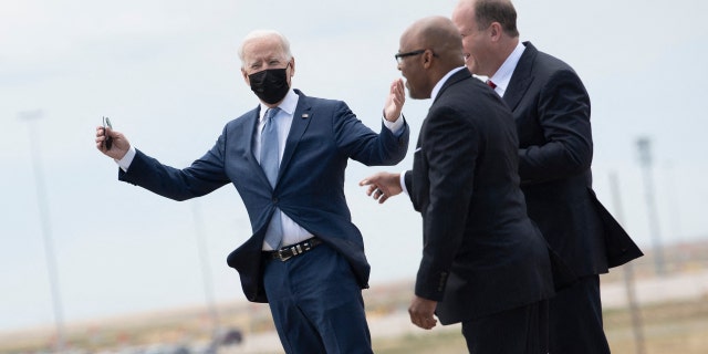 Denver Mayor Michael Hancock, center, and Colorado Gov. Jared Polis, right, greet President Biden as he arrives at Denver International Airport, Sept. 14, 2021.