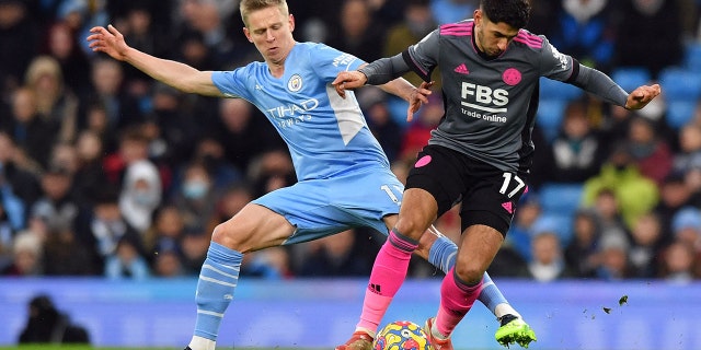 Manchester City's Ukrainian midfielder Oleksandr Zinchenko (L) challenges Leicester City's Spanish striker Ayoze Perez during the English Premier League football match between Manchester City and Leicester City at the Etihad Stadium in Manchester, England, on Dec. 26, 2021.