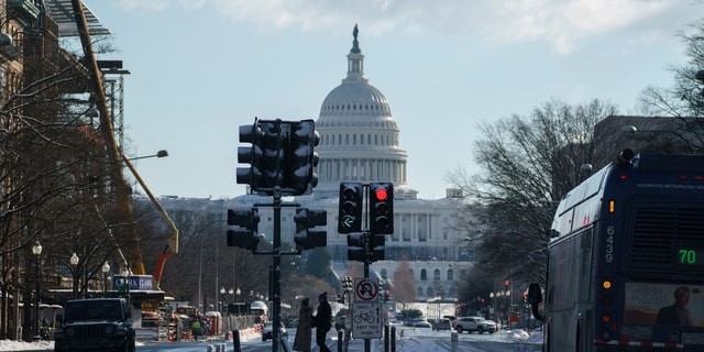 Pedestrians cross Pennsylvania Avenue near the US Capitol in Washington, DC, Jan.  7, 2022.