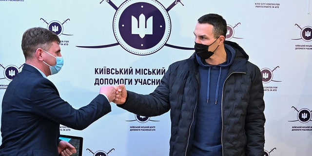 Former Ukrainian boxer Wladimir Klitschko (right) greets a staff member after he registered as a volunteer during a visit to a recruitment center in Kyiv Feb. 2, 2022.